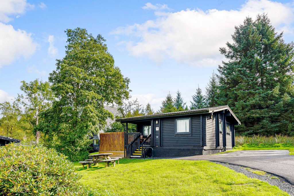 Elf Kirk Spa at Kielder Waterside. View of the single story lodge surrounded by the forest.