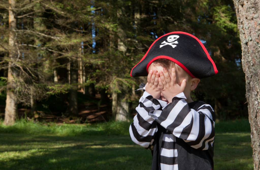 Pirates on the Ferry at Kielder Waterside. Boy dressed as pirate with hands over eyes.